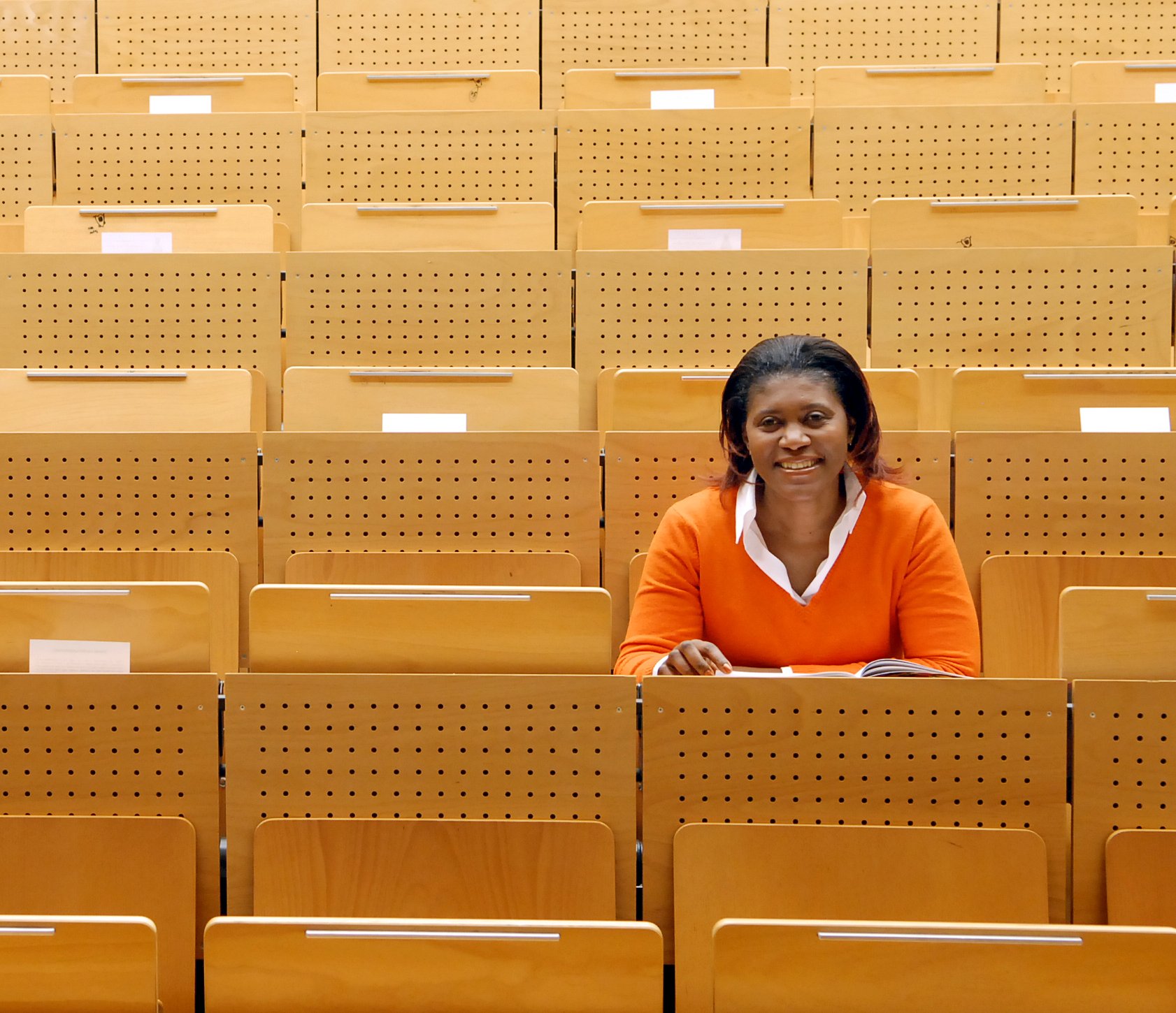 Studieneignung internationaler Bewerbender – Validität von Studieneignungstests | g.a.s.t./Wiemer Eine farbige Studentin sitzt in einem leern Hörsaal und hat ihren Blick nach vorne gerichtet.
